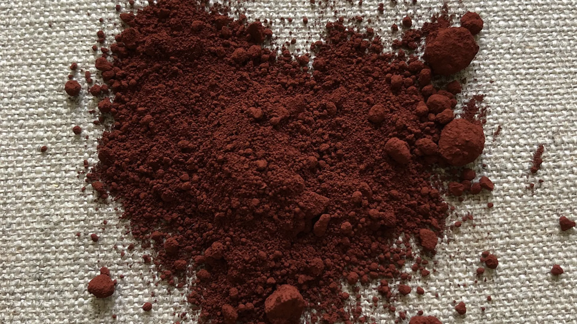 The shape of a heart made from red ochre pigment on a plain background