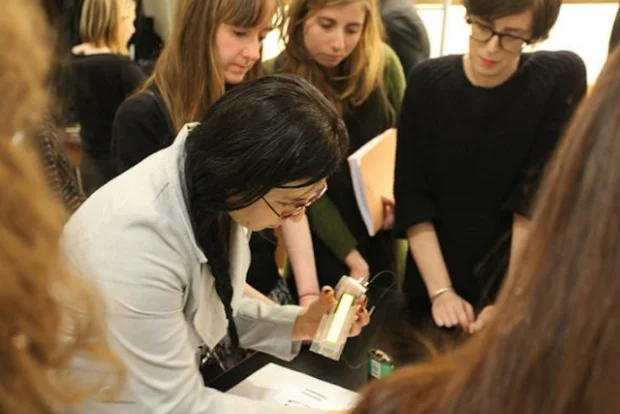 People gathered around objects on a table