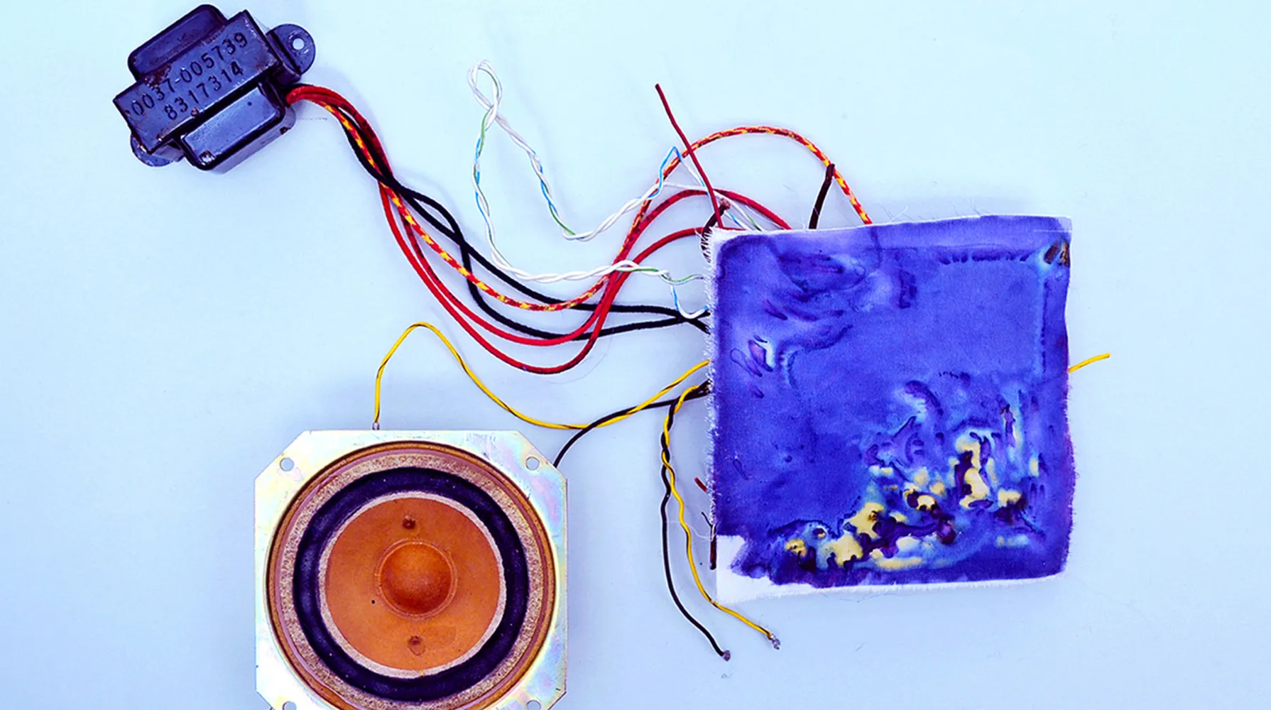 The electro colour process - featuring a circuit board covered in fabric that has been exposed, revealing yellow and blue patterns and multi-coloured wires.