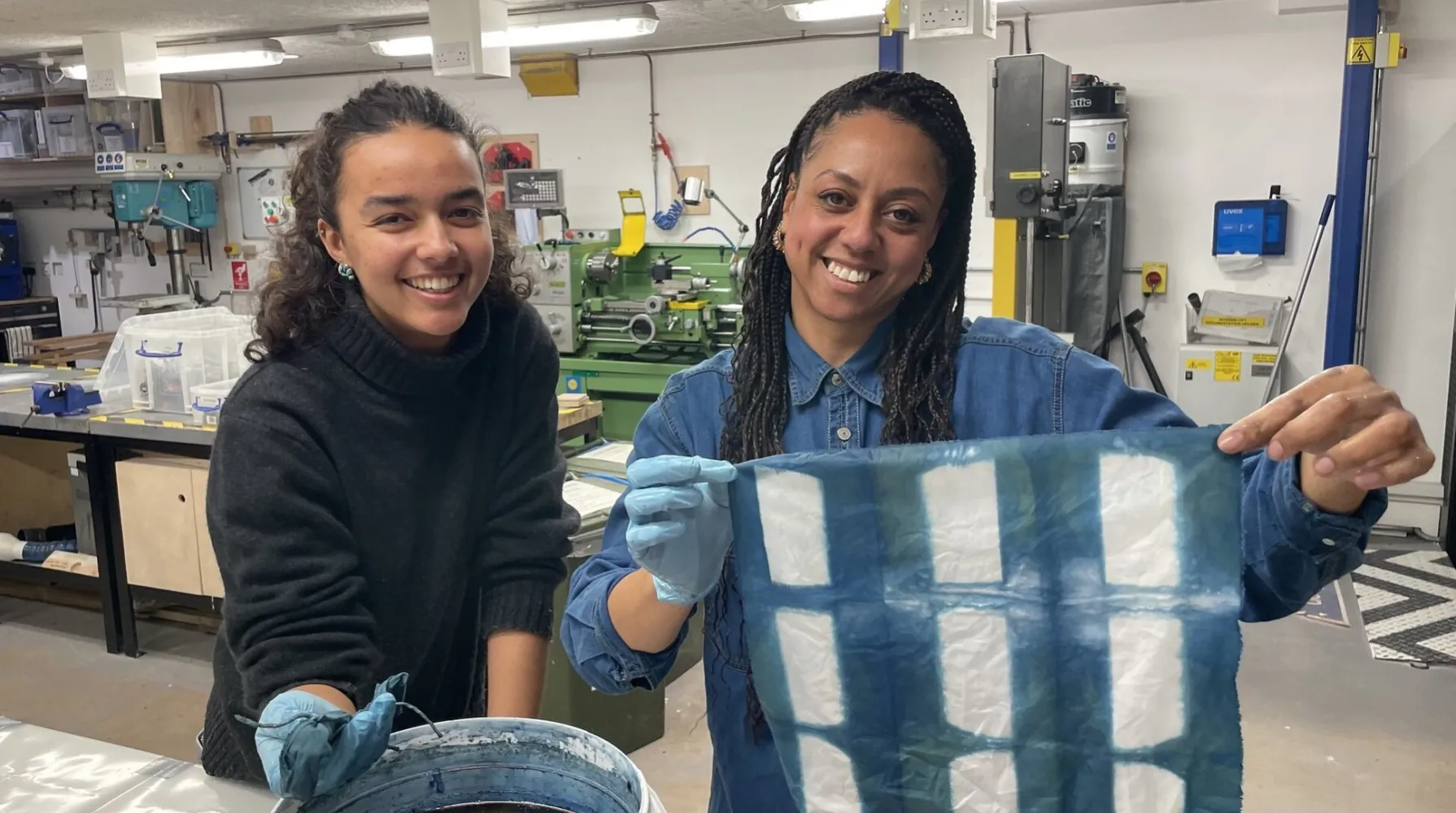 two people holding up pieces of fabric they have died indigo blue