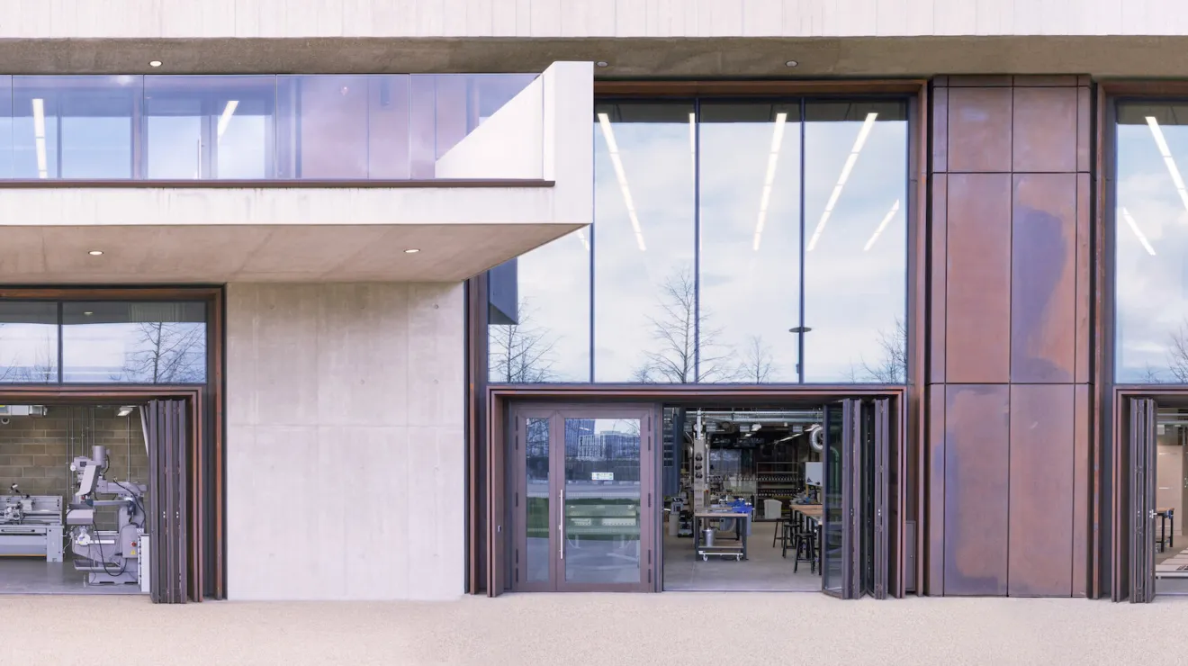 Exterior view of three large bi-fold doors open, showing a glimpse of the space and equipment within.