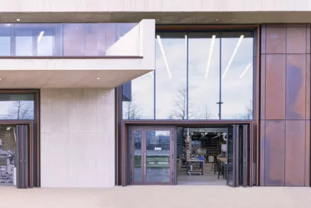 Exterior view of three large bi-fold doors open, showing a glimpse of the space and equipment within.