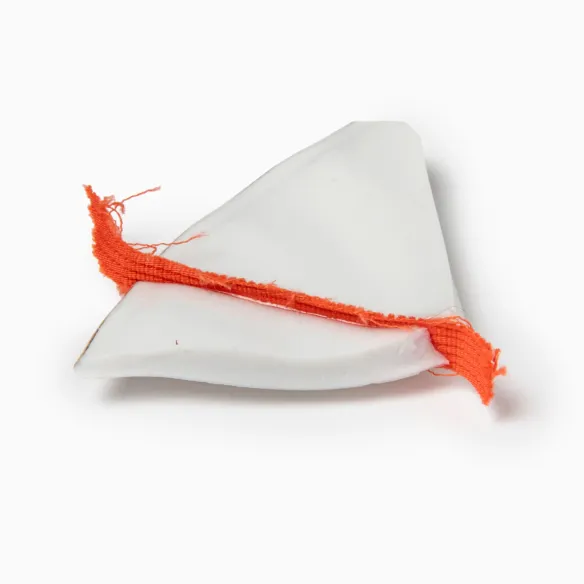 Broken ceramic fragments mended with a red piece of cloth