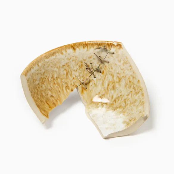 Broken ceramic fragments mended with metal staples