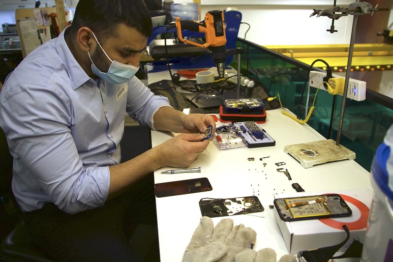 Smartphone repair - A volunteer from the Restart Project takes apart a broken smartphone brought in by a member of the UCL community.