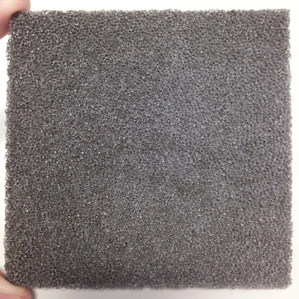 A square of a grey, silvery foam material held in between two fingers